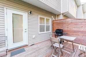A covered porch with a grill, a table, and a chair. - 4-bedroom Townhouse With AC Close to downtown (Dartmouth)