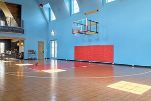 Ein Basketballplatz mit Korb, Holzboden und blauer Wand.
