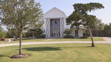 A large white barn-style building with a prominent entrance and a smaller attached structure.