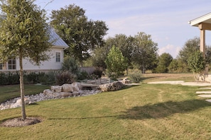 A residential property with a well-maintained lawn, a stone pathway, and a variety of trees. - Hope Ranch | Lux Estate w/ Resort Style Amenities (Round Top)