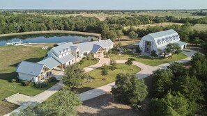 A large estate with multiple buildings, a lake, and a well-maintained lawn. - Hope Ranch | Lux Estate w/ Resort Style Amenities (Round Top)
