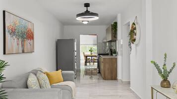 En moderne stue med en grå sofa, et billede og en loftlampe.