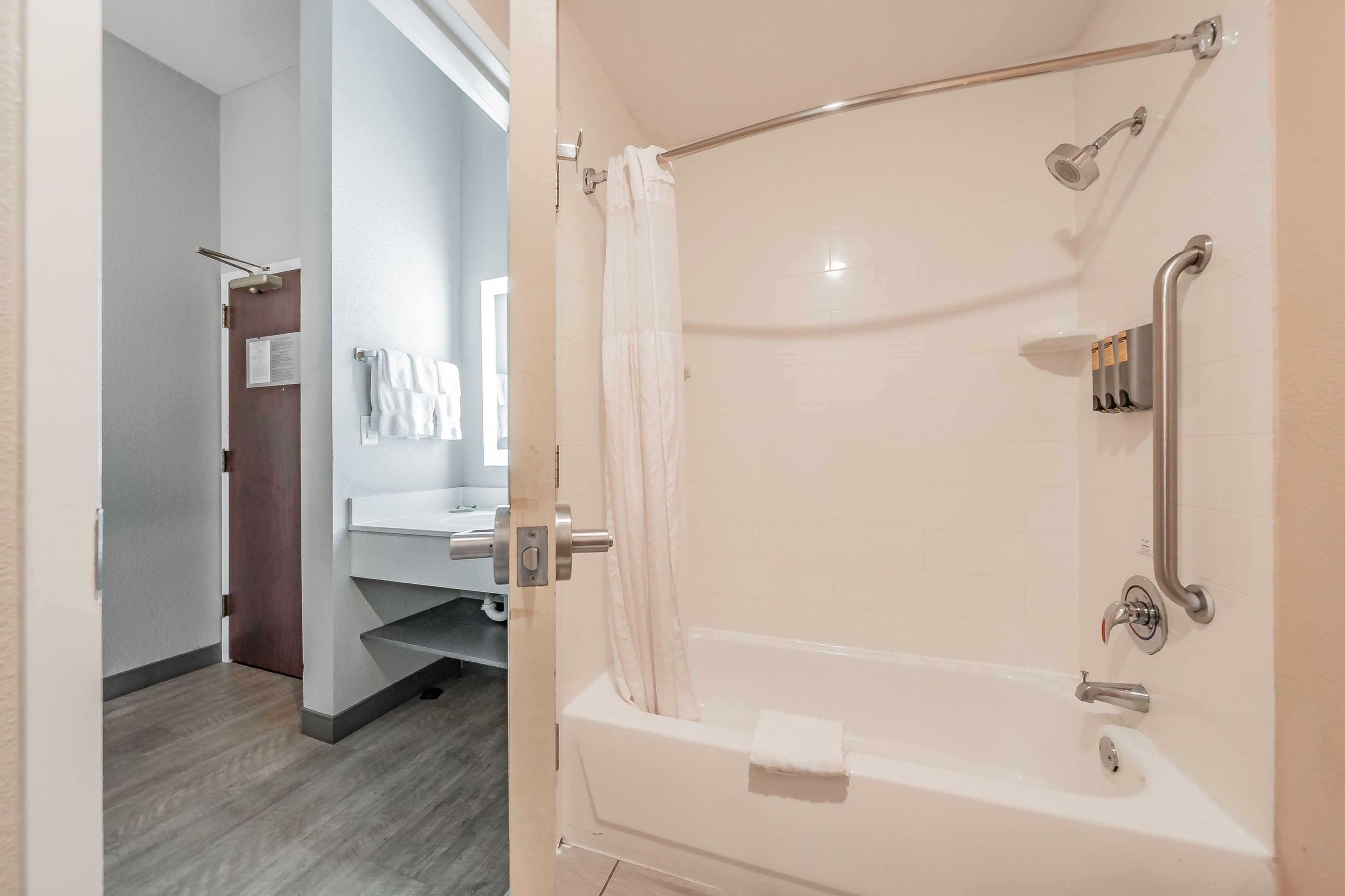 Un baño con ducha a nivel, inodoro y lavamanos.