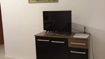 Una habitación con escritorio, televisión y un cuadro en la pared.