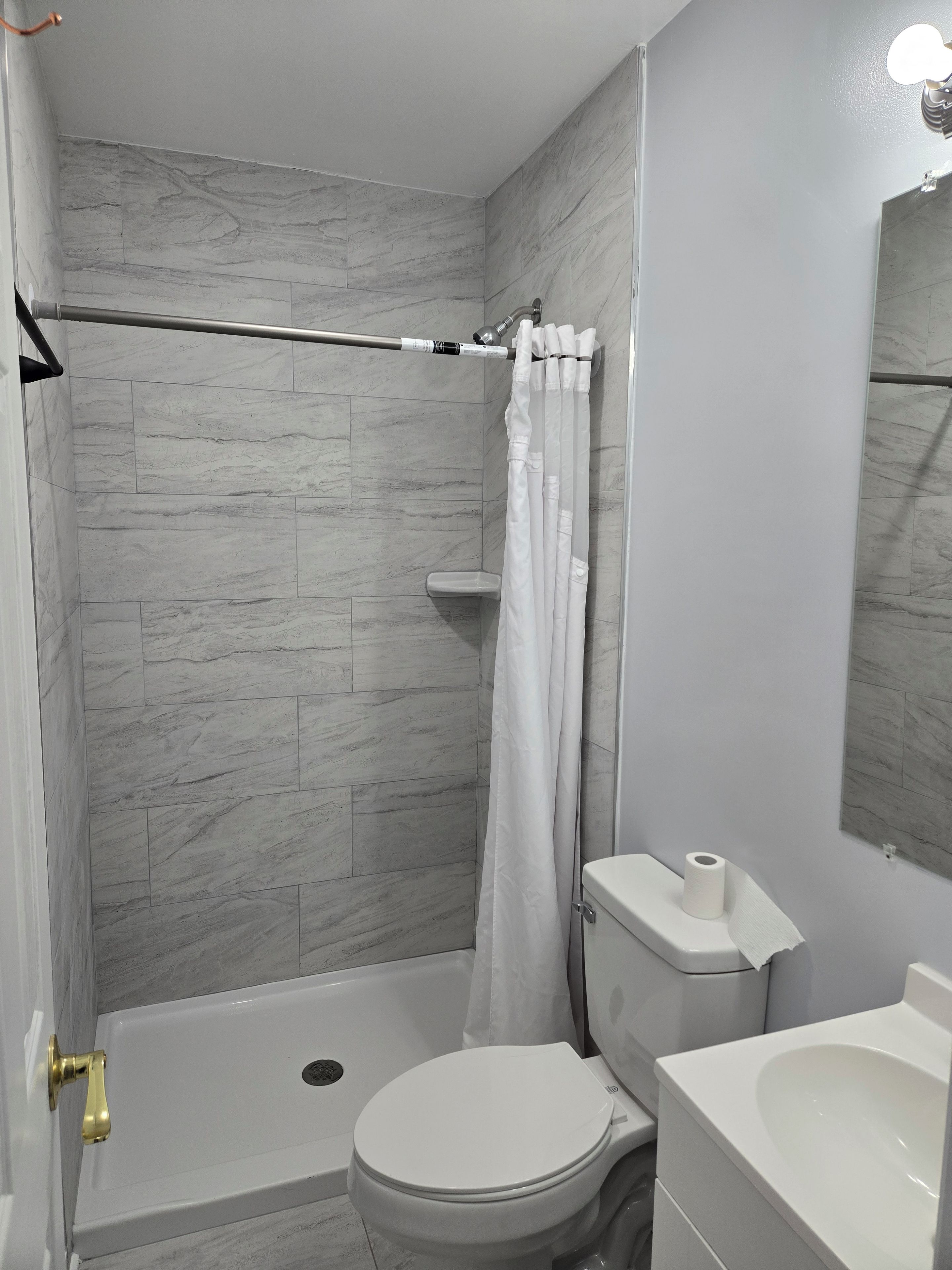 Un bagno con doccia, servizi igienici e lavandino.