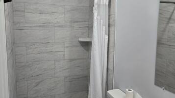 Un bagno con doccia, servizi igienici e lavandino.