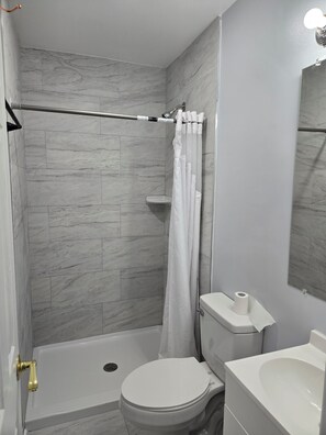 Un baño con ducha, inodoro y lavamanos.