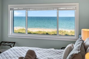 A room with a large window overlooking a beach and ocean. - TIDE & SHELL - Remodeled Oceanfront Jensen Beach Retreat w/Private Beach & Pools (Jensen Beach)