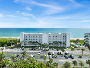 A hotel with a parking lot, a pool, and a beach view. - TIDE & SHELL - Remodeled Oceanfront Jensen Beach Retreat w/Private Beach & Pools (Jensen Beach)
