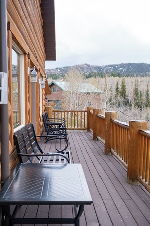 A wooden deck with a table and chairs, overlooking a mountainous landscape. - Deer Creek Mountain Retreat (Heber City)