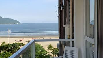 Uma varanda com vista para a praia e o oceano.