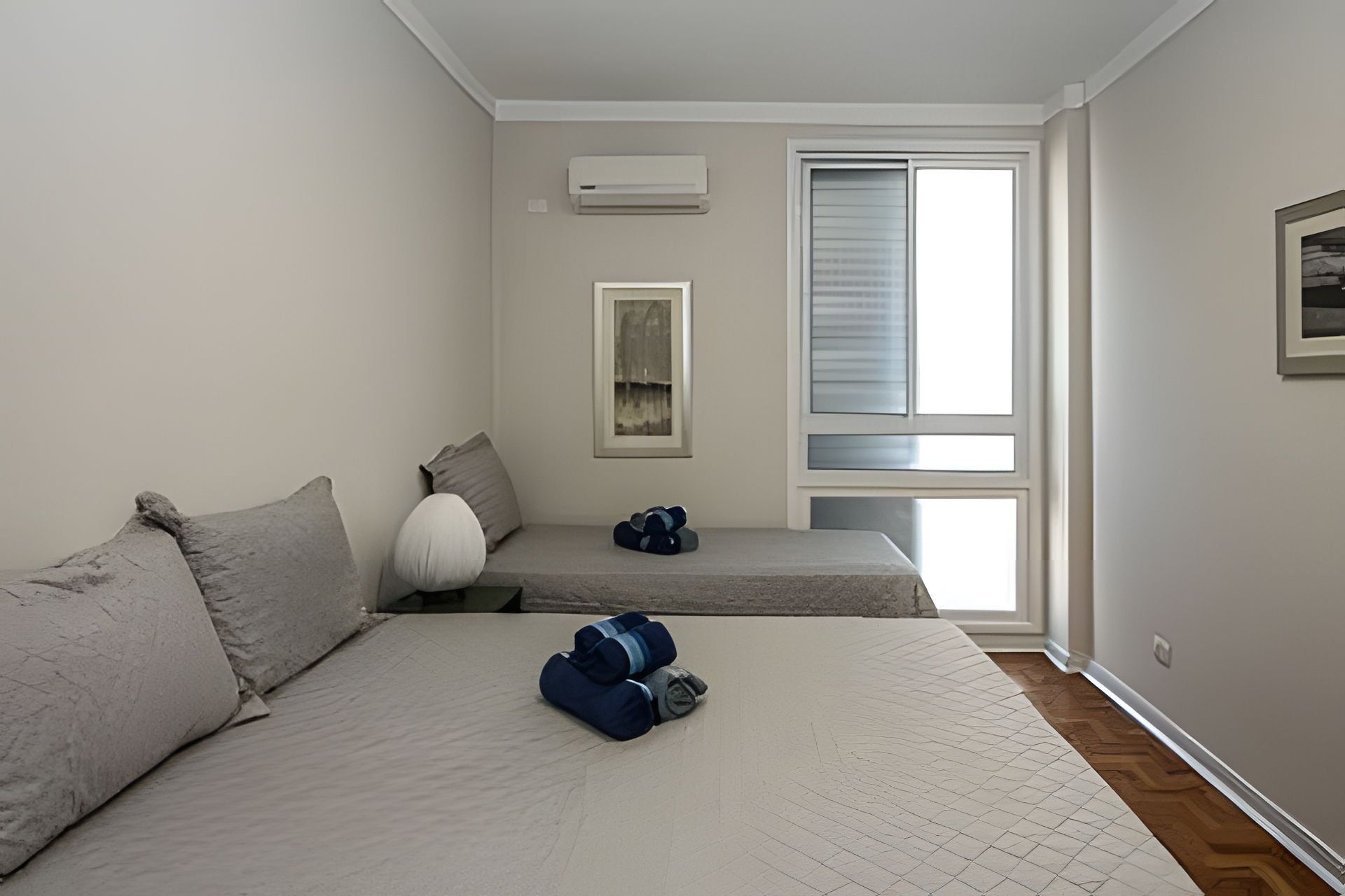 Un dormitorio con cama, un banco y una ventana.