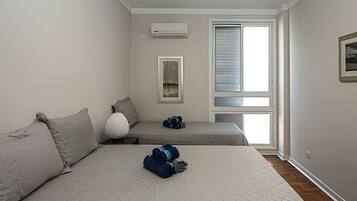 Un dormitorio con cama, un banco y una ventana.