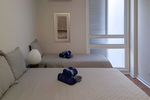 A hotel room with two beds, a large window, and a painting on the wall. - SHB - Gonzaga Beach Vibes Pé na Areia (Santos)