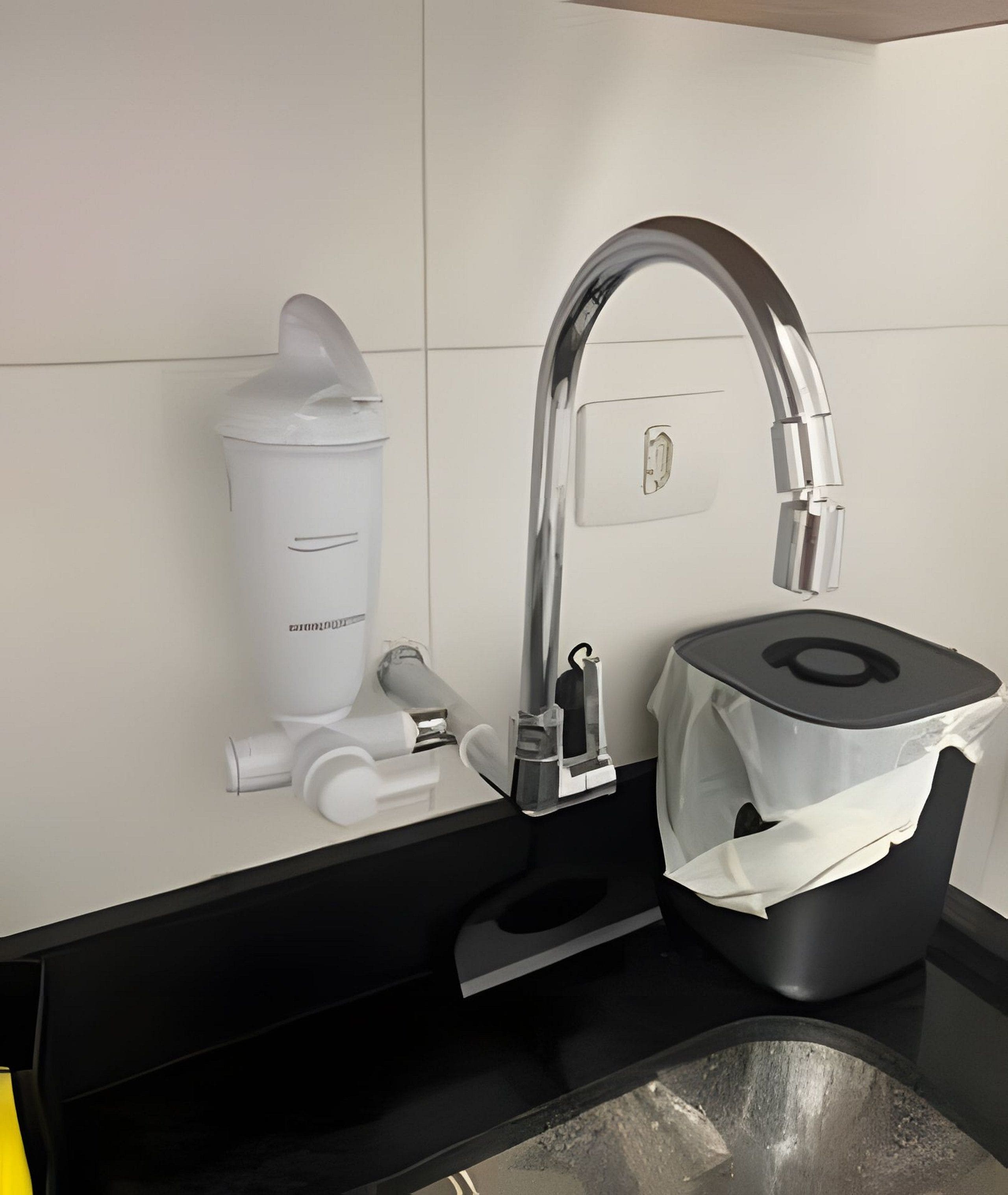 Et moderne badeværelse med en sort bordplade, et hvidt toilet og en sølvarmatur.
