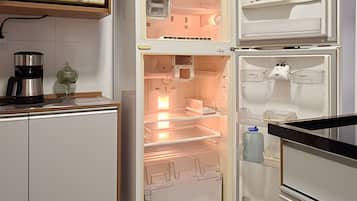Una cocina moderna con un refrigerador empotrado y una cafetera sobre la encimera.