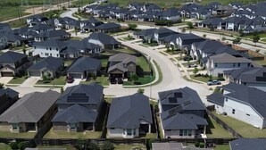 Un quartier résidentiel comprenant plusieurs maisons, des rues et un ciel dégagé.