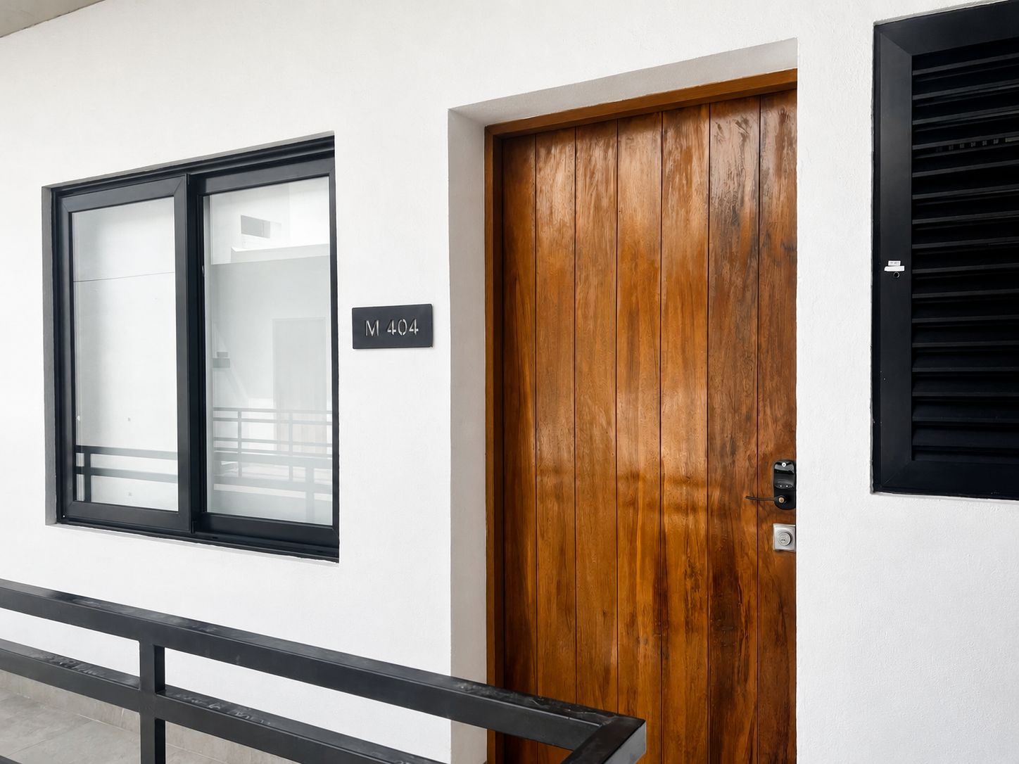 Une porte en bois avec une poignée noire et une fenêtre dotée d’un cadre noir.