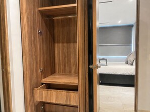 Une armoire en bois dotée de plusieurs étagères et d’une porte-miroir.