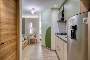 A modern kitchen with a stainless steel refrigerator, a microwave, and a coffee machine. - Edificio Vita Habitare (Cali)