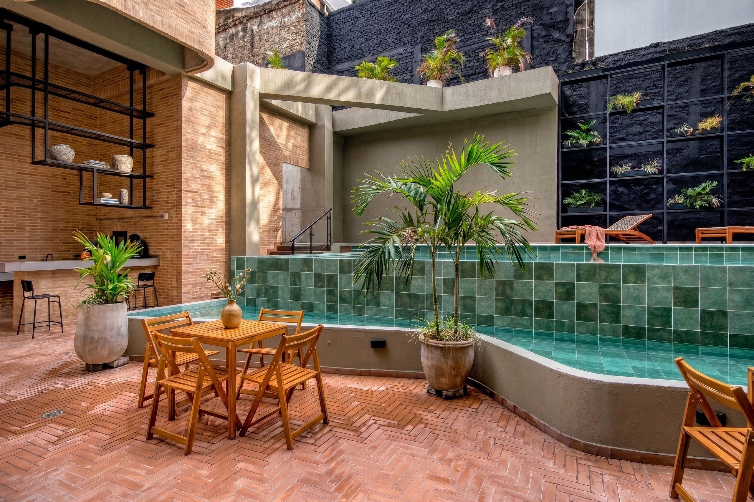 Un área de patio al aire libre con piscina, mobiliario de madera y plantas en macetas.