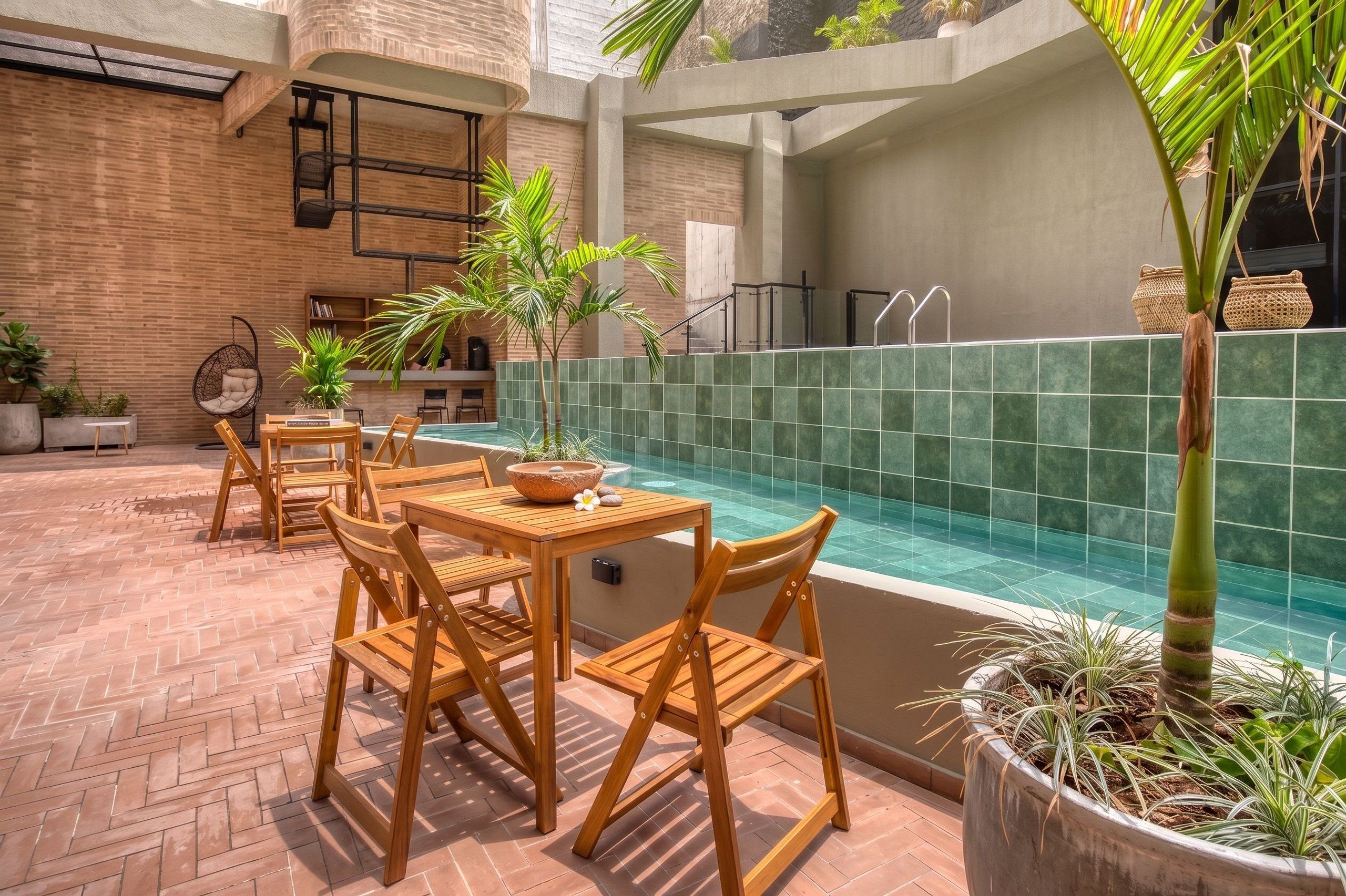 A pool area with wooden furniture and potted plants.