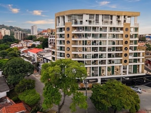 Un edificio de varios pisos con balcones, ventanas grandes y techo plano.