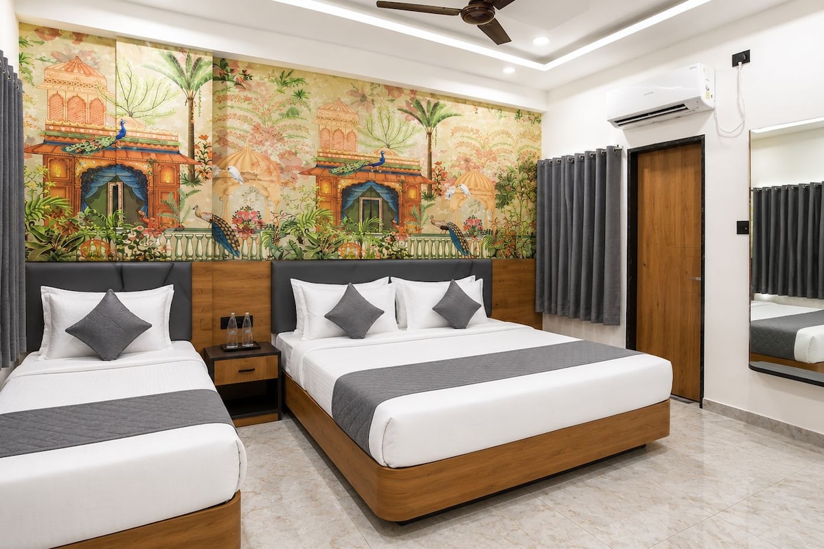 A hotel room with two beds, a mural, a ceiling fan, an air conditioning unit, and a mirror.