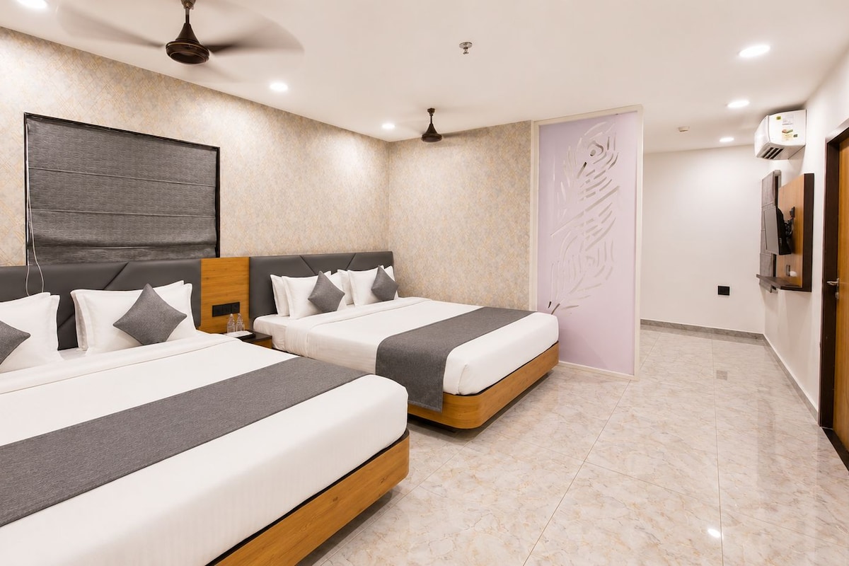 A hotel room with two beds, a ceiling fan, an air conditioning unit, and a decorative wall panel.