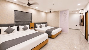 A hotel room with two beds, a ceiling fan, an air conditioning unit, and a decorative wall panel. - Hotel Shree Dwarka Devbhumi Dwarka (Dwarka)