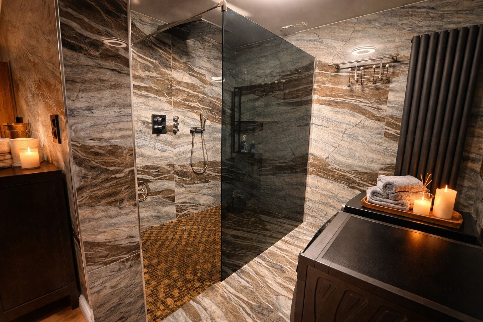 Ein modernes Badezimmer mit einer gläsernen Duschkabine, Marmorwänden und einem Waschtisch mit Kerzen.