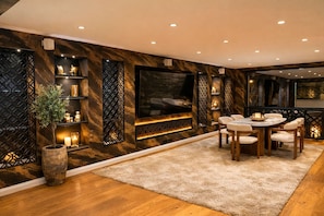A modern dining area with a round table, chairs, and a fireplace. - Villa Vibes (Essen)