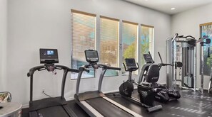 Ein Fitnessraum mit Laufbändern, Crosstrainern und Kraftgeräten.
