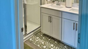 A modern bathroom with a glass shower enclosure, a large mirror, and a white sink. - Modern Stay w/ 2 King Beds | Near Elon & Downtown (Graham)