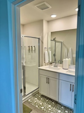 A modern bathroom with a glass shower enclosure, a large mirror, and a white sink. - Modern Stay w/ 2 King Beds | Near Elon & Downtown (Graham)