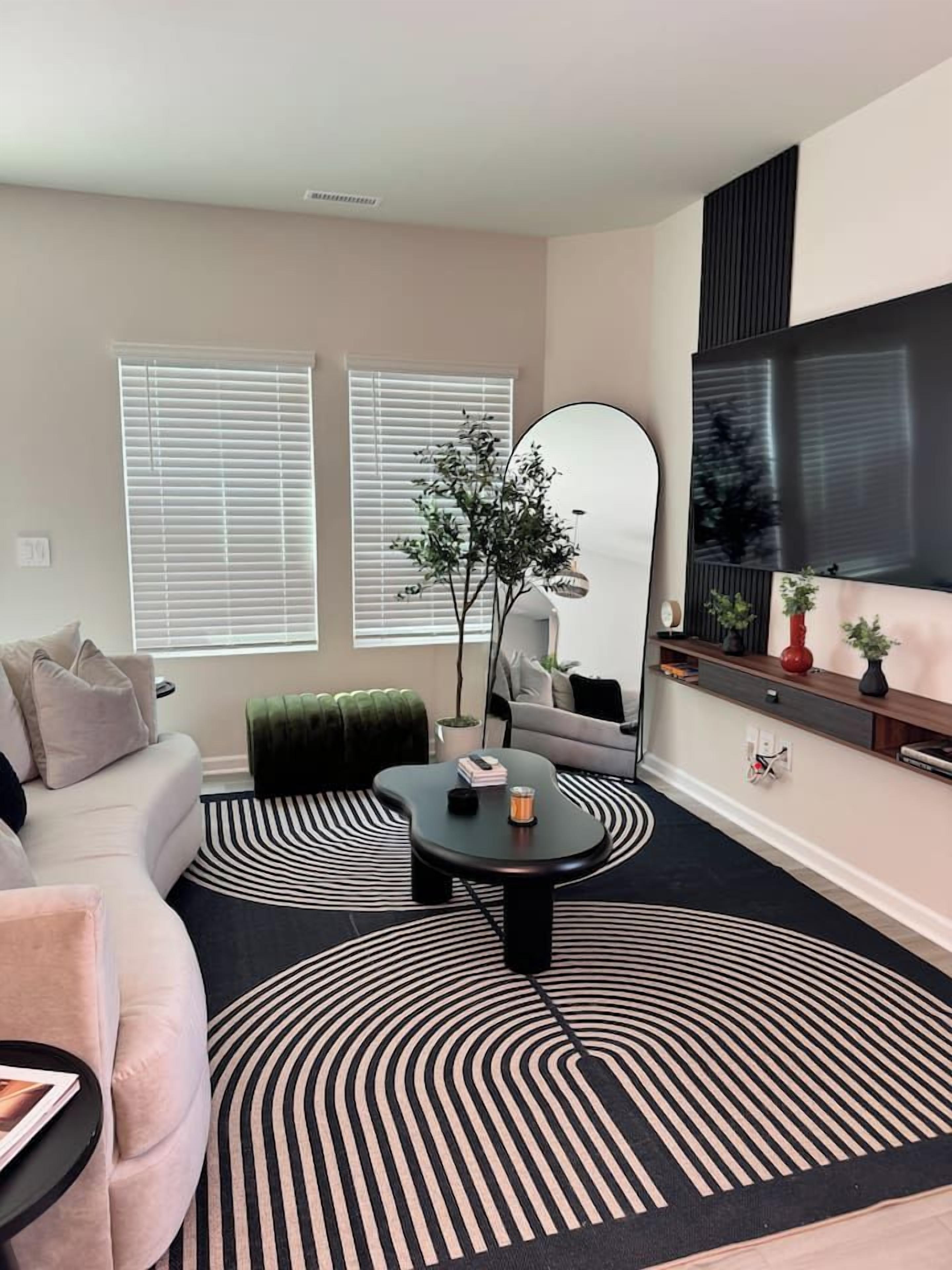A modern living room with a sofa, coffee table, and a large mirror.