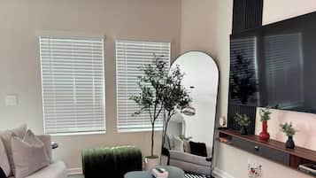 A modern living room with a sofa, coffee table, and a large mirror.