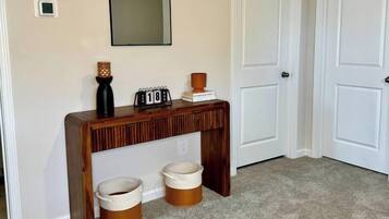 A hallway with a wooden console table, a mirror, and two doors.