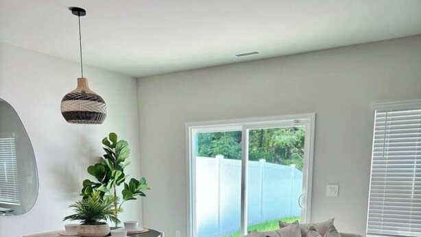 A modern living room with a round dining table, a sofa, a small side table, and a hanging light fixture. - Modern Stay w/ 2 King Beds | Near Elon & Downtown (Graham)