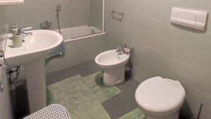 Ein Badezimmer mit Waschbecken, Bidet, Toilette und Duschbereich.