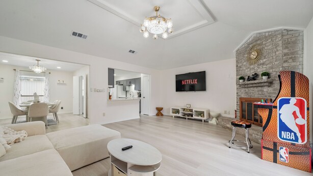 Un salon moderne avec une cheminée, un téléviseur et un coin repas.