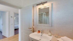 Een hotelbadkamer met een wastafel, spiegel en toiletartikelen.