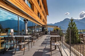 An outdoor terrace with wooden tables and chairs, large windows, and a view of mountains. - Wifi, ski-in/ski-out & foot of the slopes, fitness, sauna, hammam, tv, ski locker, 35-39m², Vercorin (Vercorin)
