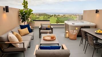 Un área de estar moderna al aire libre con jacuzzi, una mesa de comedor y vistas del paisaje.