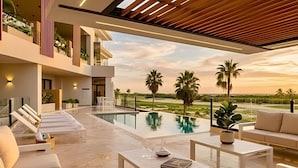 A modern outdoor living area with a pool, lounge chairs, and a view of the landscape. - The Penthouse at Vista Alta (Punta Cana)