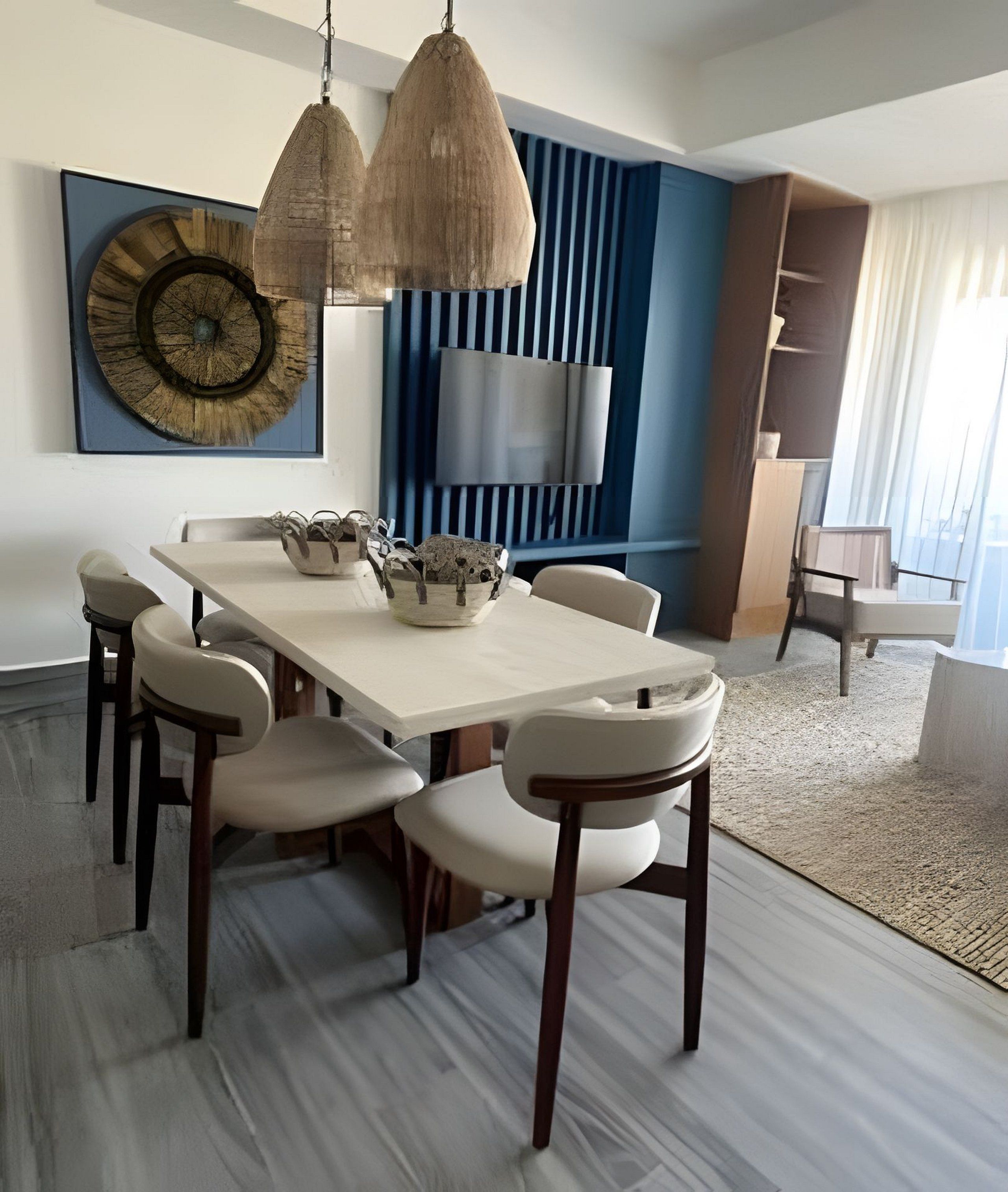 Un comedor moderno con una mesa larga, sillas y lámparas colgantes.