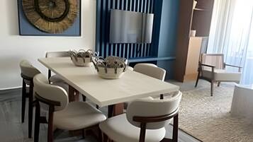 Un comedor moderno con una mesa larga, sillas y lámparas colgantes.