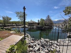 Une propriété située au bord d’un lac, dotée d’une terrasse en bois, d’un chemin en pierre et d’une clôture en métal.