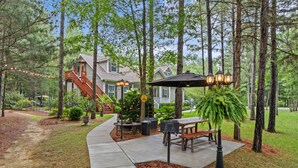 A residential property with a patio area, outdoor furniture, a barbecue grill, and a staircase leading to the house. - Private 1BR Retreat Among the Pines - Sleeps 4 - Unit 1 (Indian Trail)