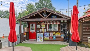 A rustic ice cream parlor with a red door, outdoor seating, and string lights. - Private 1BR Retreat Among the Pines - Sleeps 4 - Unit 1 (Indian Trail)